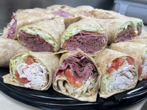 Party tray of corned beef rollup sandwiches and turkey wraps.